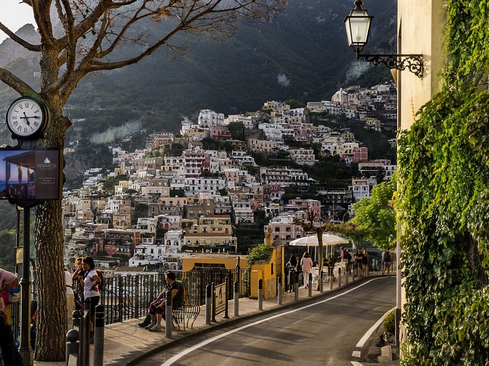 Positano, Italy street with houses on a hill and a clock