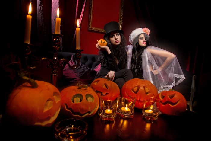 Halloween pumpkins and two women with candles