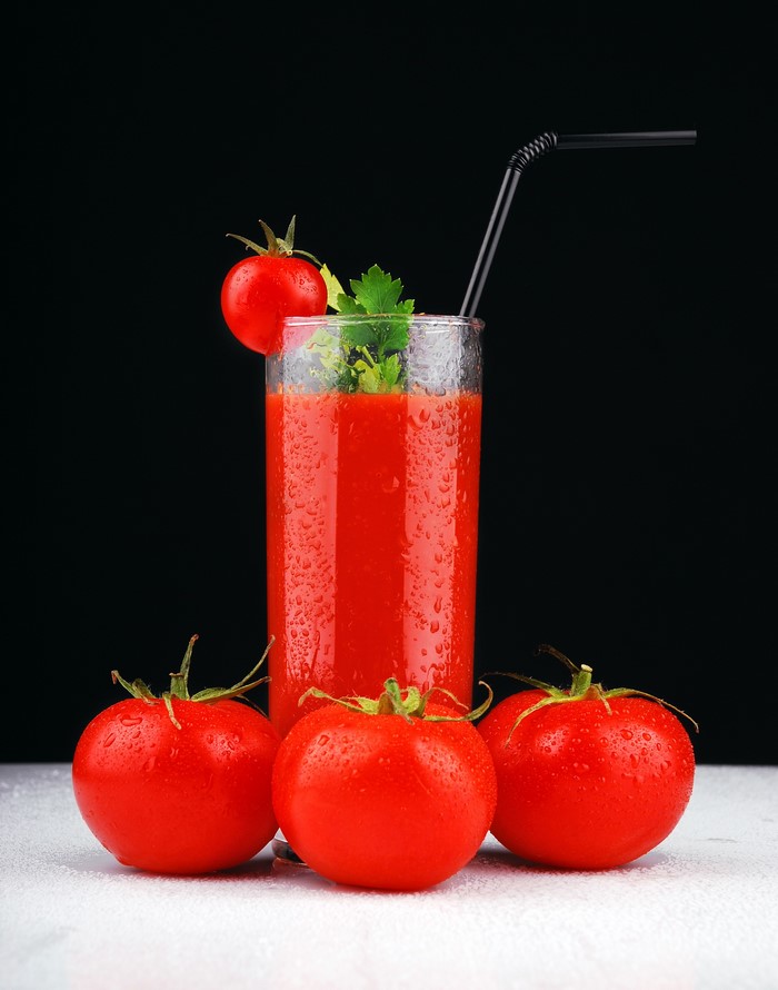 Tomato juice in a highball glass with tomatoes