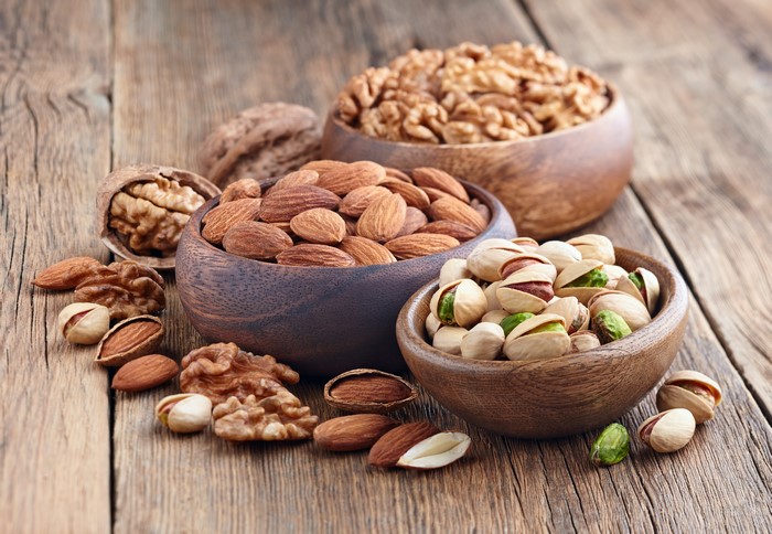 Assortment of Nuts in Wooden Bowls on Wood Planks