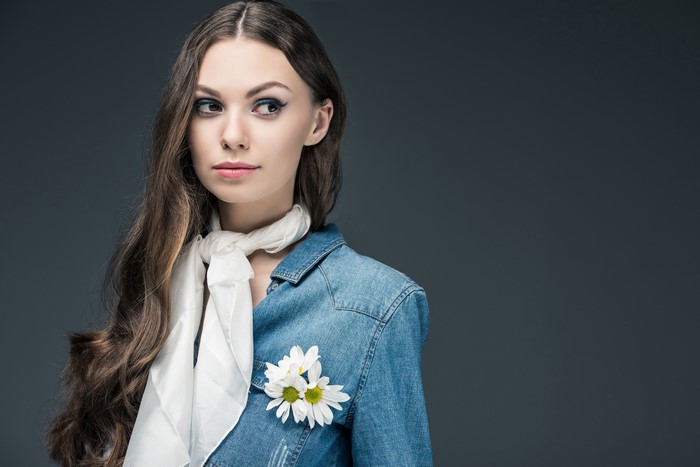 Woman with brown hair wearing a denim shirt and scarf