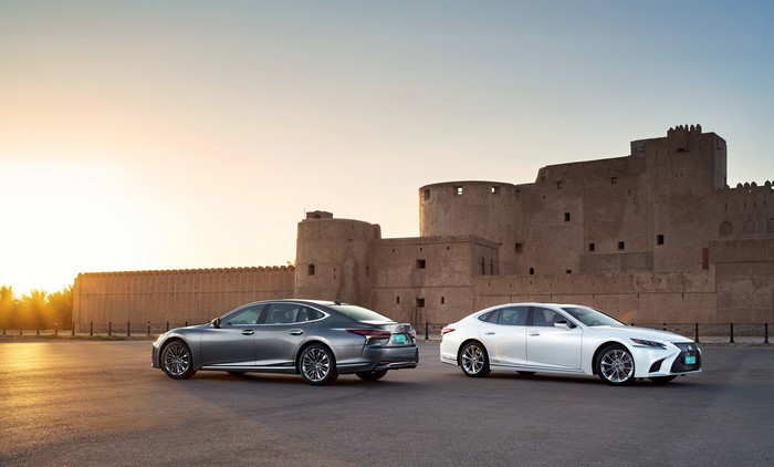 Two Lexus LS 500h AWD cars in front of a castle