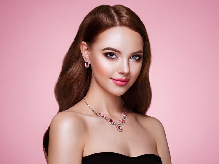 Elegant Woman with Jewelry and Necklace on Pink Background