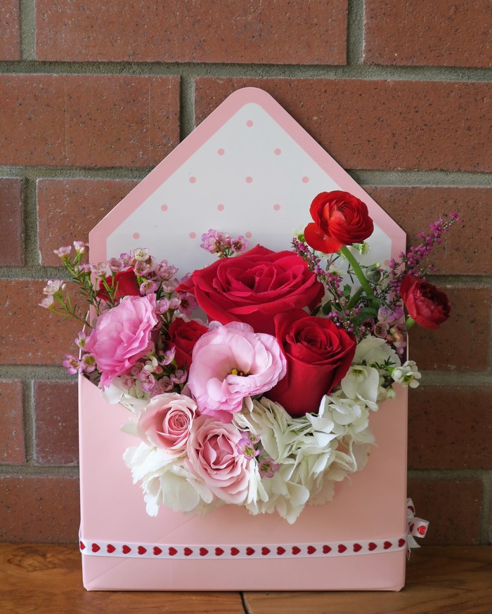 Pink envelope flower arrangement with roses and hydrangeas