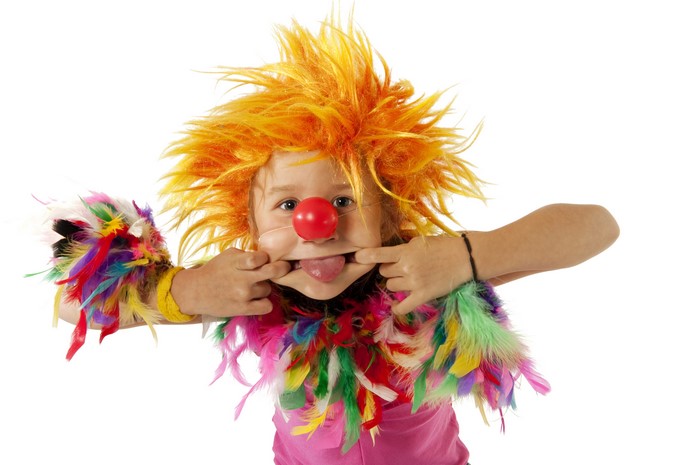Child dressed as a clown with orange wig and red nose
