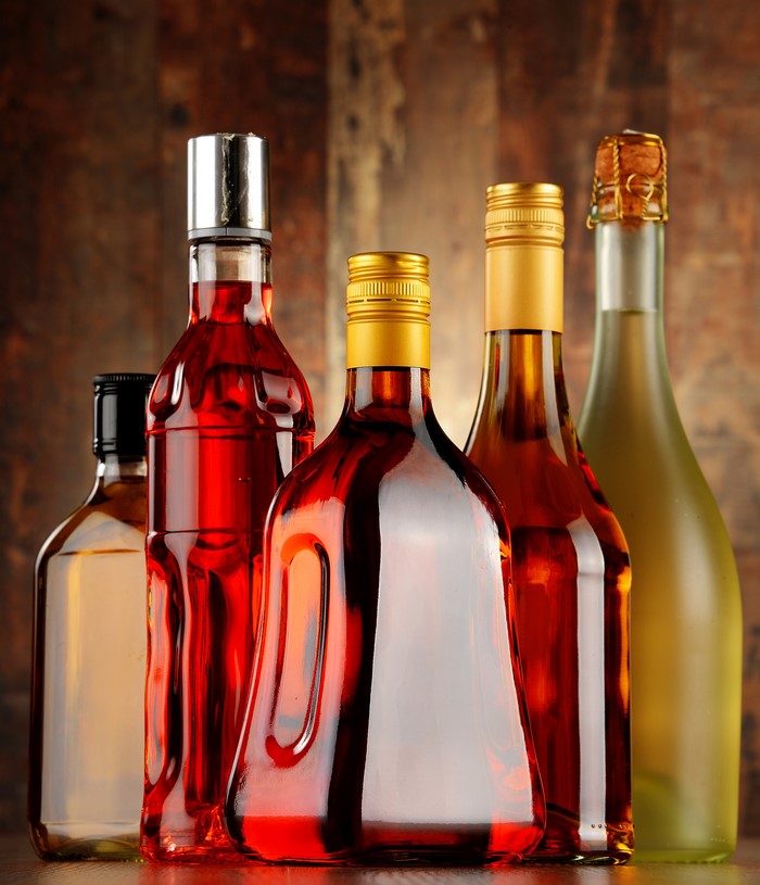 Bottles of alcoholic drinks on a wooden background
