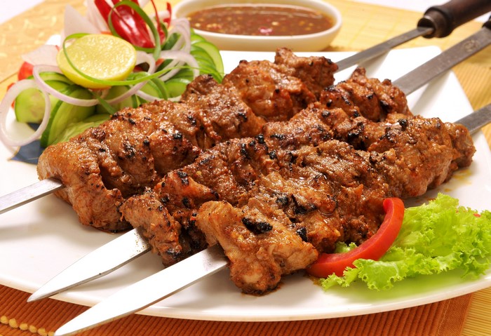Meat kebabs on skewers with salad and dipping sauce