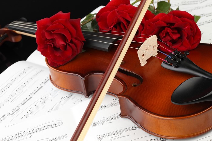 Violin with red roses and sheet music