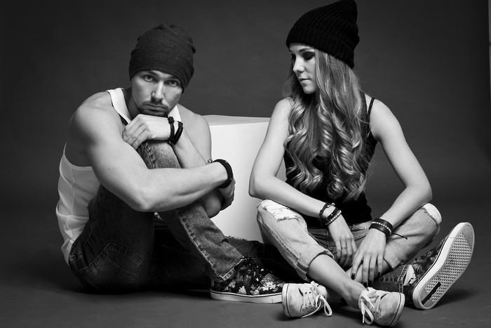 Man and woman wearing winter hats sitting on floor