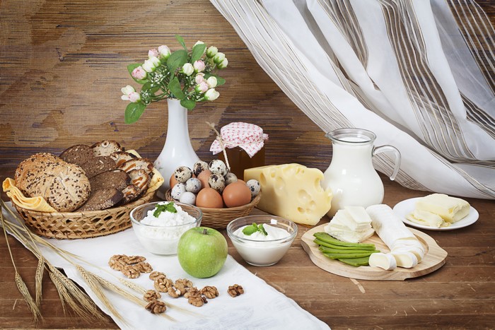 Breakfast spread with bread, cheese, eggs, and milk