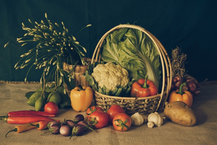 Vegetables in a wicker basket with a dark background