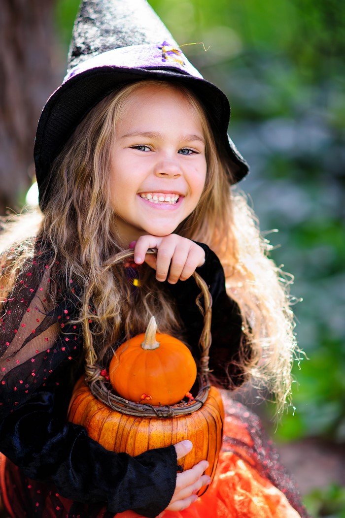 Girl in Witch Costume Holding Pumpkin Basket