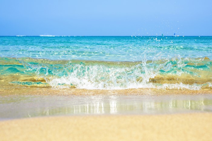 Ocean wave crashing on a sandy beach
