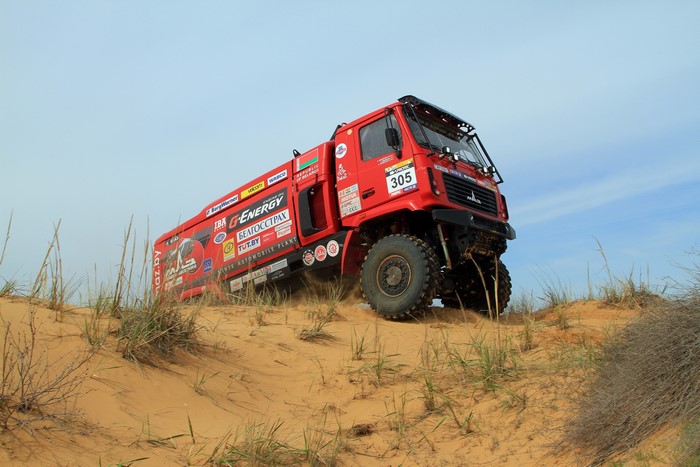 Red MAZ-5309RR rally truck driving on sand dunes