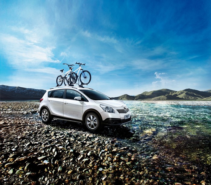 White Toyota E'z Cross with bicycles on roof rack