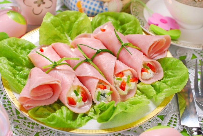 Ham rolls with cream cheese filling and chives on lettuce