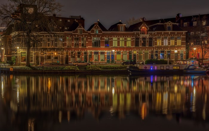 Houses and boats on a canal at night in Groningen, Netherlands