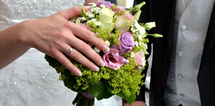 Bride's Hand with Wedding Ring and Bouquet