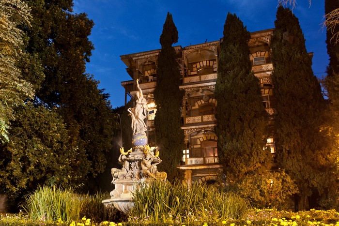 Fountain sculpture in front of a building at dusk