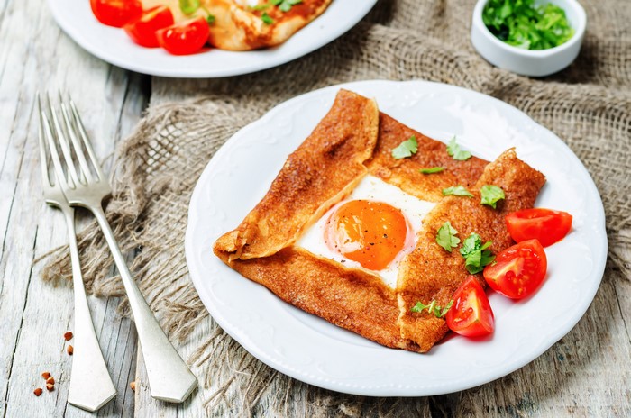 Fried egg in a crepe with tomatoes