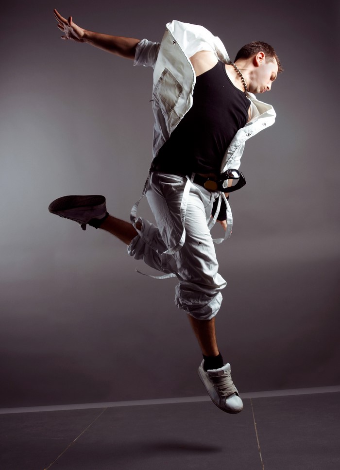 Man in white jacket and black tank top jumping