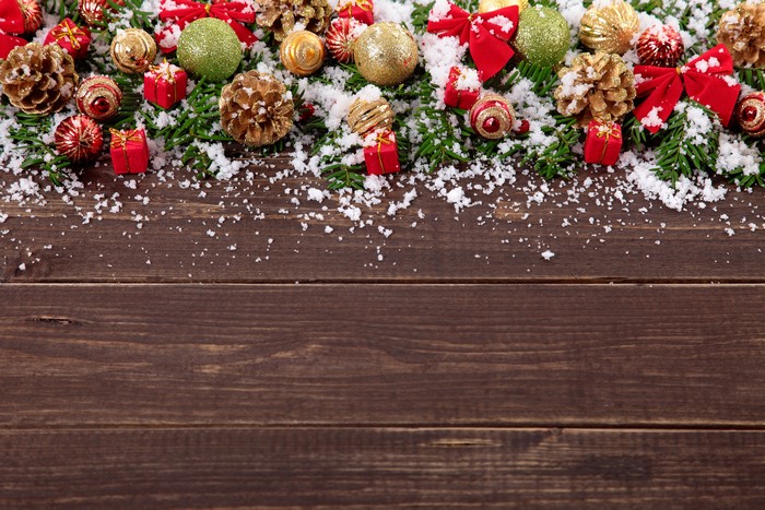 Christmas decorations with pine cones and snow on wood planks