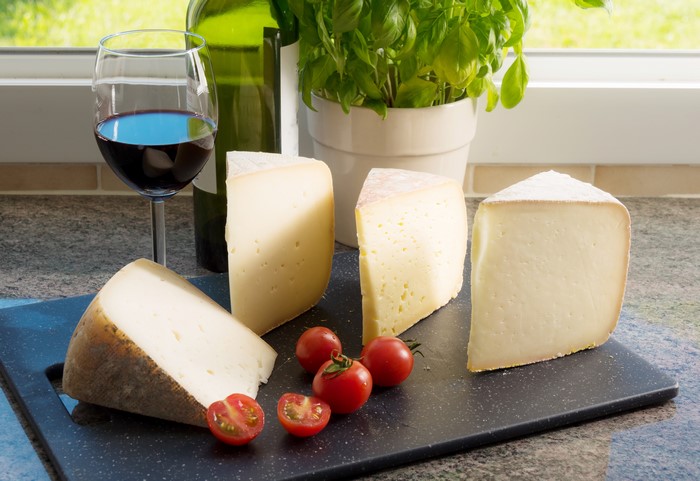 Cheese, Wine, and Tomatoes on a Cutting Board