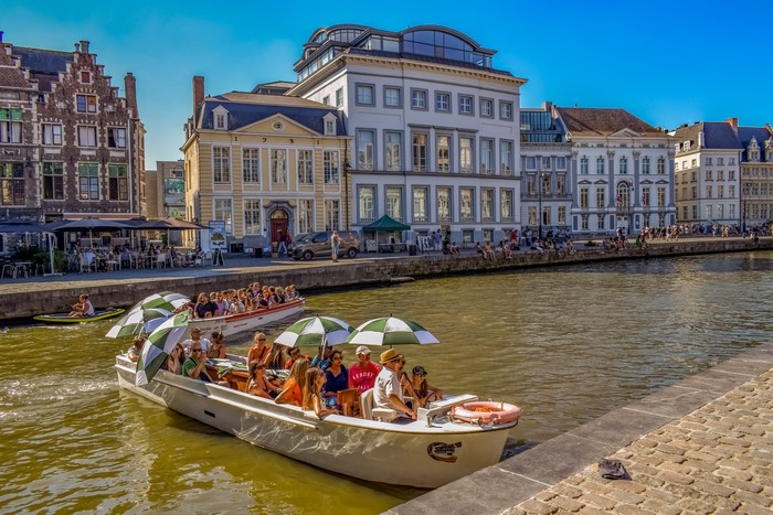 Boats on a canal in Ghent, Belgium with historic houses