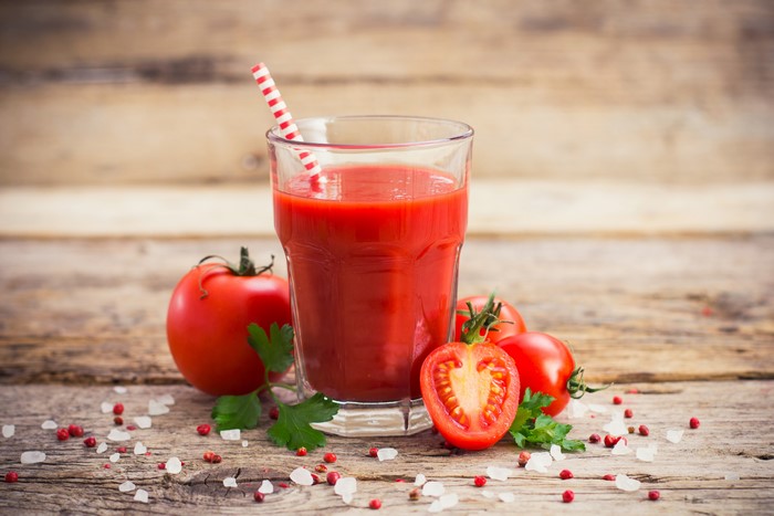 Tomato juice in a glass with tomatoes and spices