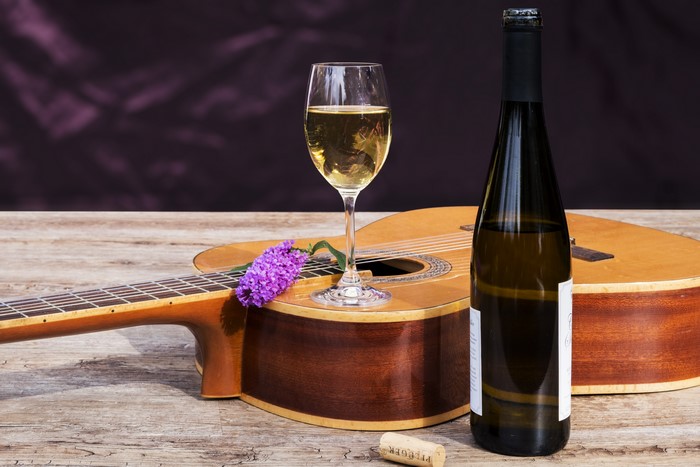 Wine bottle, glass, and guitar with flower
