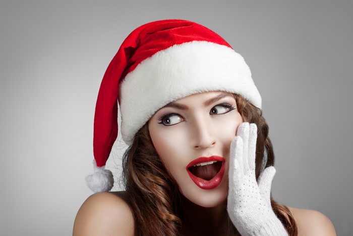 Woman in Santa hat with surprise emotion