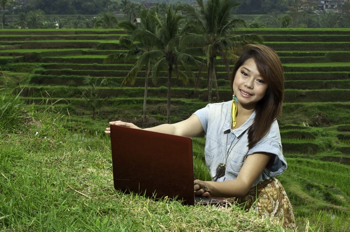 Asian woman with laptop in rice terraces