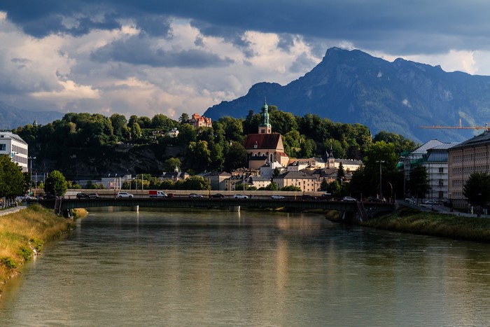 Salzburg cityscape with river, bridge, and mountains