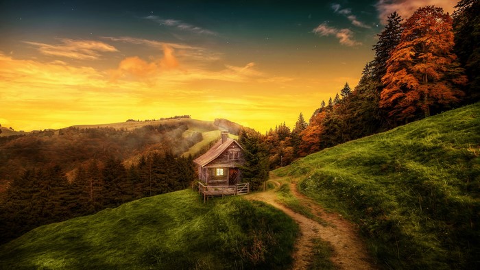 Cabin in the mountains at sunset with autumn trees