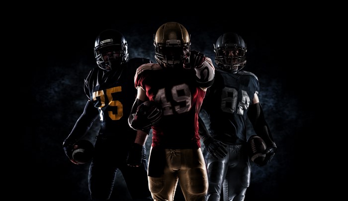 Three American Football Players in Uniforms