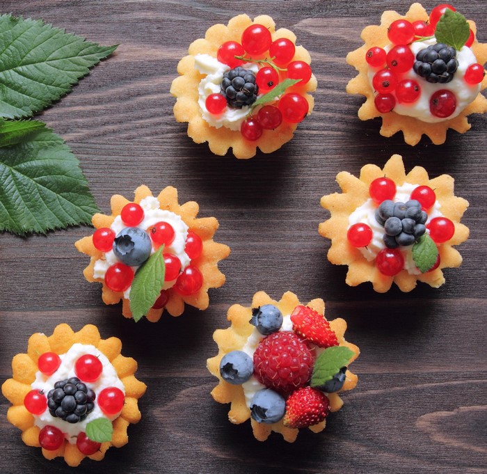 Berry tarts with cream and mint leaves