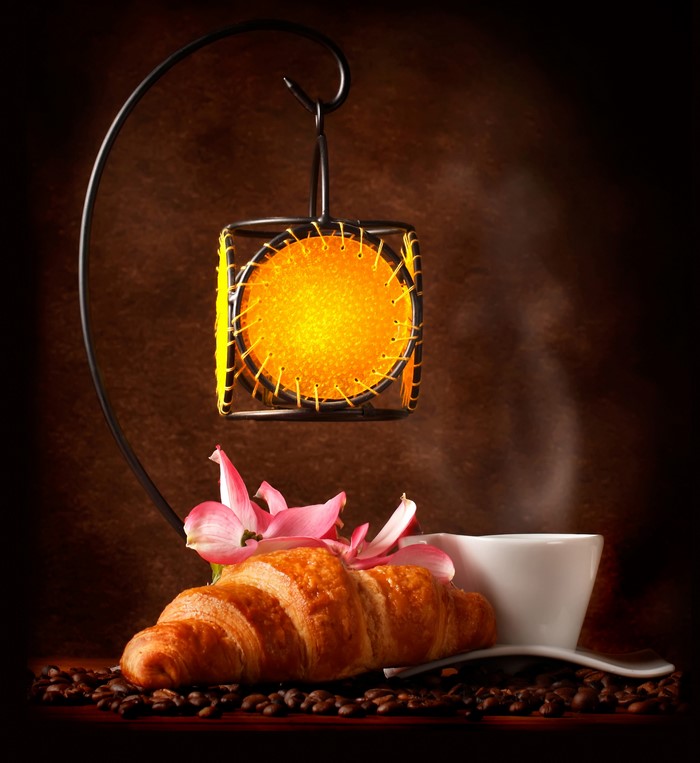 Croissant, coffee cup, and lantern with flowers