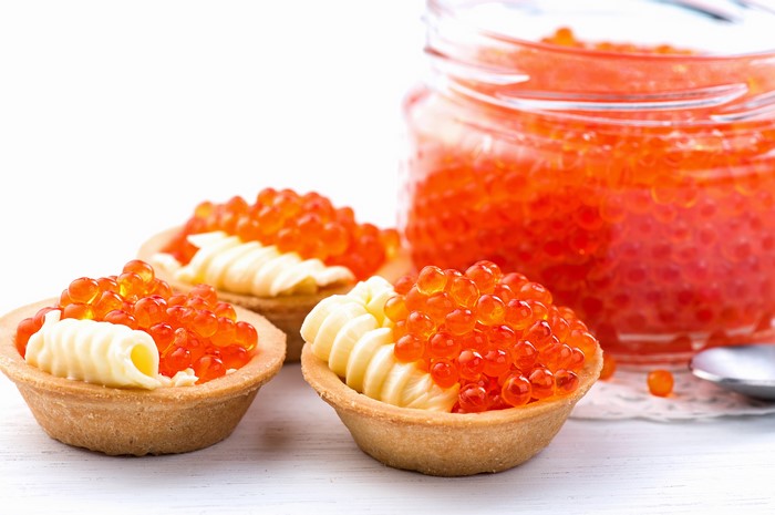 Tartlets with butter and red caviar in a jar