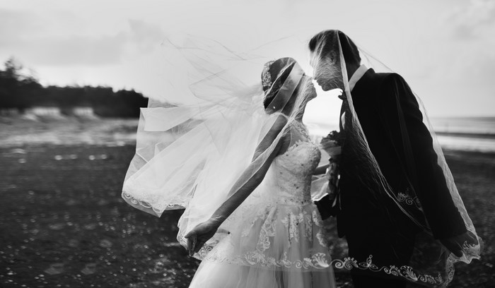 Bride and Groom Kissing Under Veil