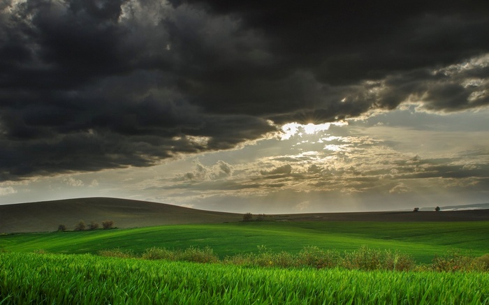 Stormy sky over green rolling hills