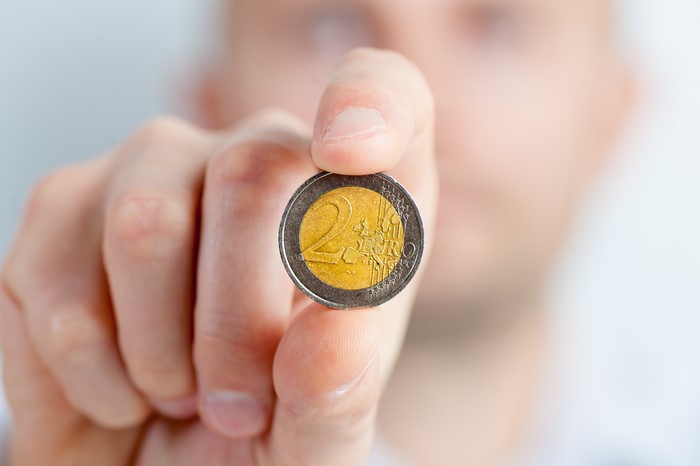 Person holding a 2 Euro coin