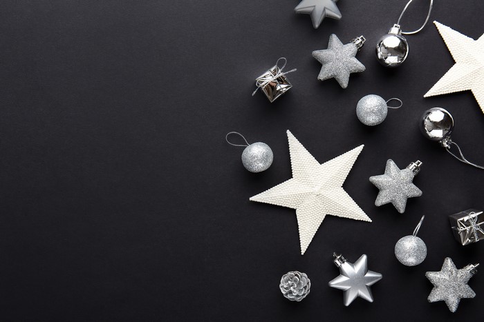 Christmas ornaments: stars, balls, and gifts on black background