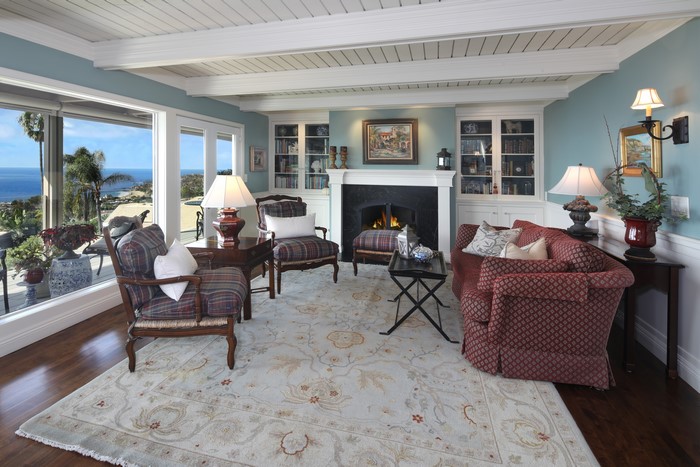 Living room with ocean view, sofa, and armchairs