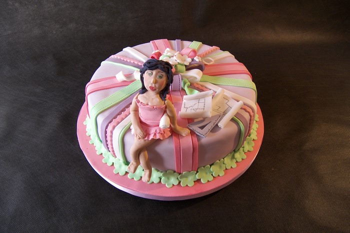 Cake decorated as a gift with a fondant figure and blueprints