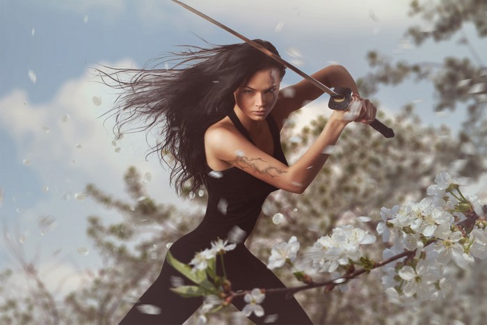 Woman with sword in black outfit with cherry blossoms