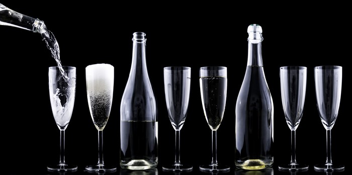 Champagne bottles and glasses on black background