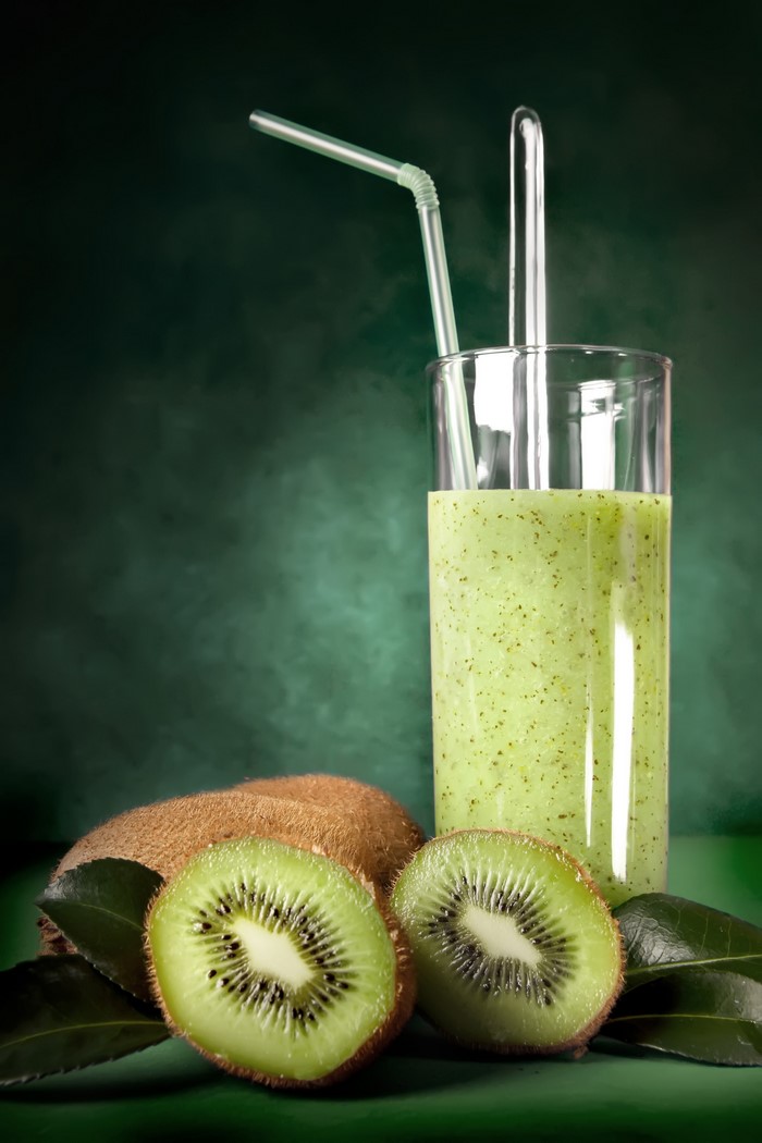Kiwi smoothie in a highball glass with kiwis