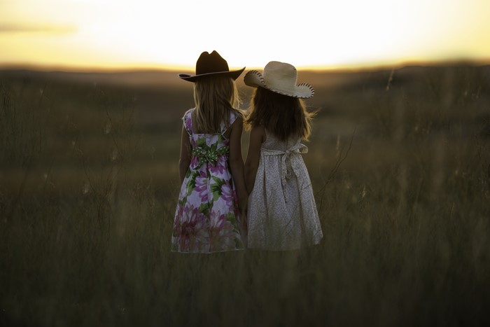 Two little girls in hats at sunset