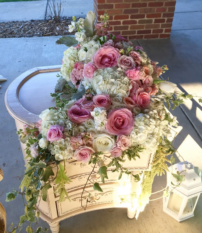 Pink and white floral arrangement on a vintage table