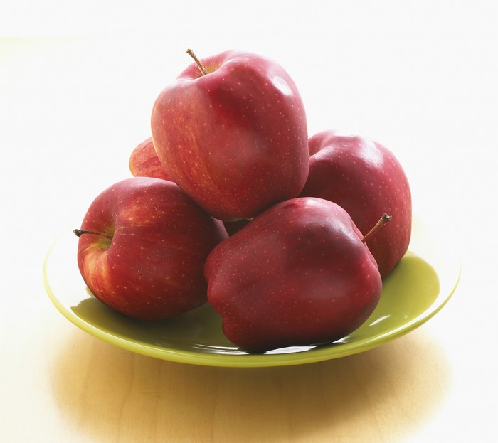 Red apples on a green plate